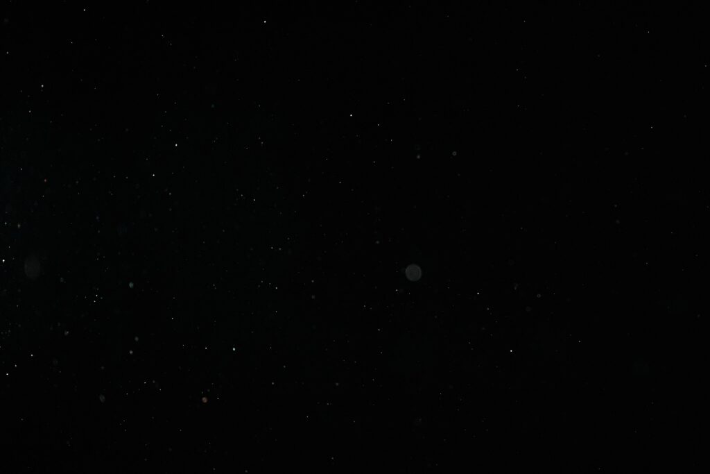 Creative abstract image of particles on a black background resembling a starry night sky.